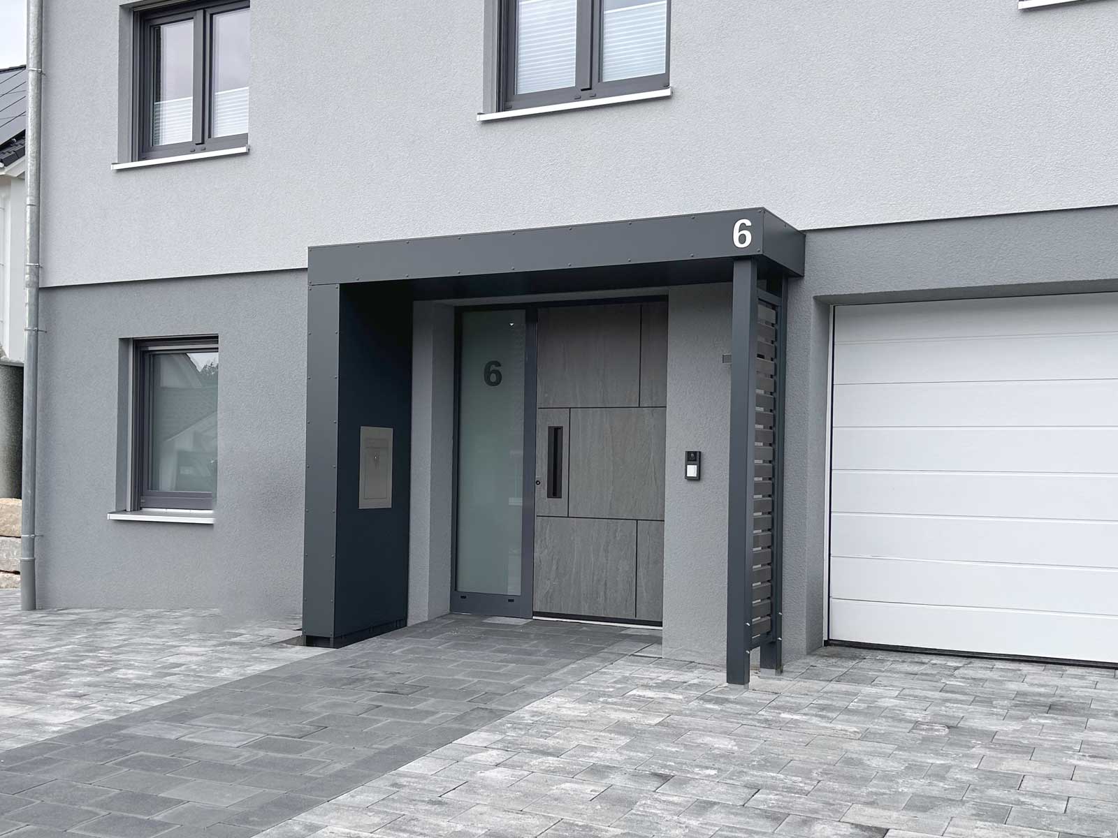 Vordach Serie S.1 von Siebau. Zwei Stützen an der offenen Seite mit Sichtschutzelement Holzlattung