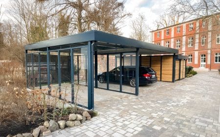 Carport aus Metall mit Glas-Windschutz und Geräteraumanbau
